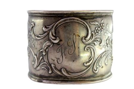 Argola de guardanapo em prata com motivos florais relevados envolvendo cartela para monograma.